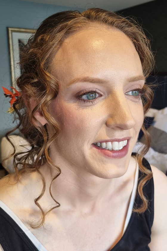 Curly-haired client with green eyes and natural blush makeup